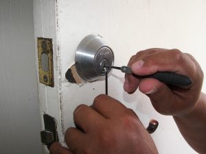Locksmith prying open a a door. 