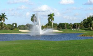 Pond with a waterfall and palm trees in the background at a Miami, Florida Golf Course. 