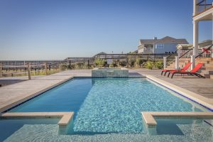 Outdoor Pool near a beach setting displaying the need for a Swimming Pool Maintenance Company. 