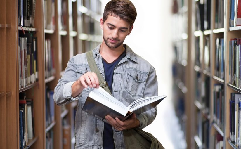 College student walking through a library.